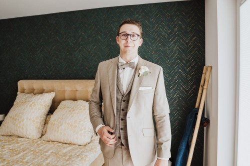 Ein Bräutigam steht im Schlafzimmer.