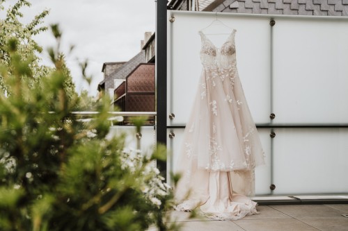 Ein Brautkleid hängt auf einer Terrasse.