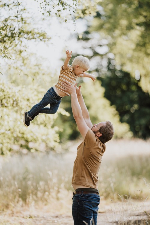 Ein Mann wirft ein Kind in die Luft.