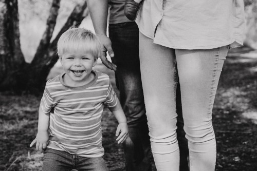 Ein kleiner Junge steht neben einem Mann und einer Frau.