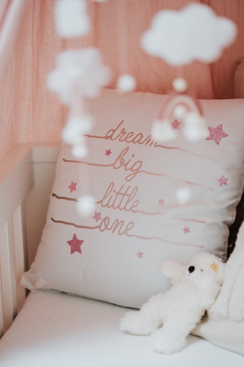 Ein Kopfkissen mit pinker Schrift.