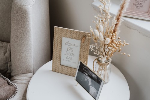 Ein Bilderrahmen, getrocknete Blumen und Ultraschallbild auf einem Couchtisch.