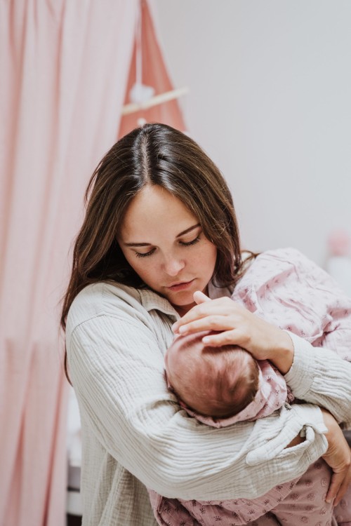 Eine Frau hält ein kleines Baby auf dem Arm.