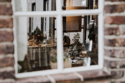 Ein Blick durch ein Fenster zu dekorierten Tischen.