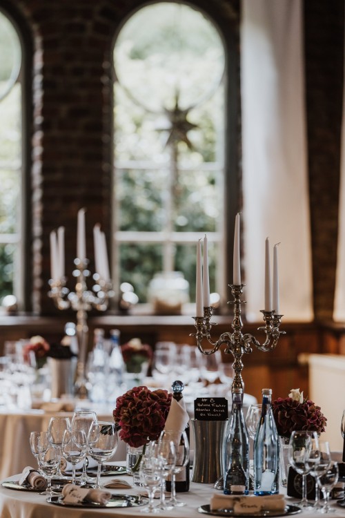 Ein festlich dekorierter Tisch mit Blumen und Kerzenständer.