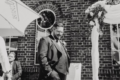 Ein Schwarz-weißes Bild von einem Mann vor einem Gebäude.