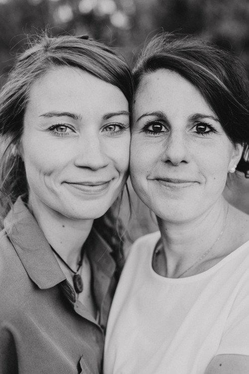 Zwei Frauen schauen in die Kamera.