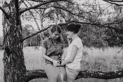 Zwei Frauen sitzen auf einem Ast.