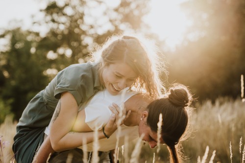 Eine Frau nimmt eine zweite Frau huckepack.