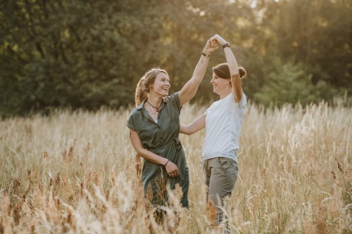 Zwei Frauen tanzen mitten auf der Wiese.