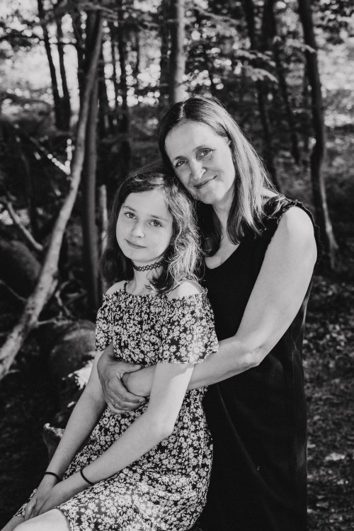 Eine Frau umarmt ein Mädchen.