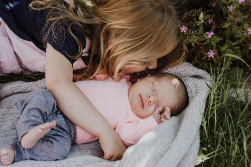 Ein Kind kuschelt ein kleines Baby.