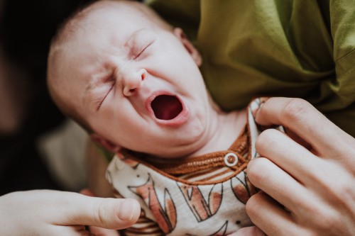 Ein kleines Baby gähnt.