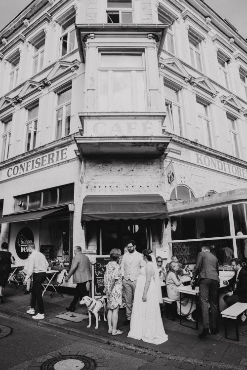 Eine Gruppe von Menschen die vor einem Cafe stehen.