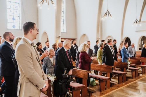 Menschen stehen in einer Kirche.