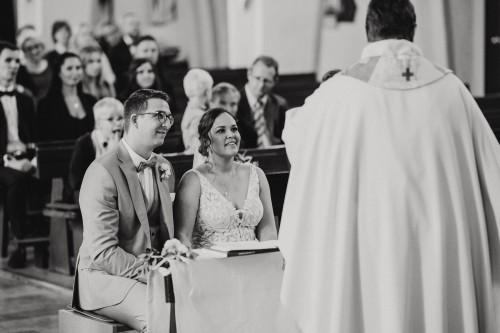 Ein schwarz-weißes Bild von einer Braut und Bräutigam in einer Kirche.