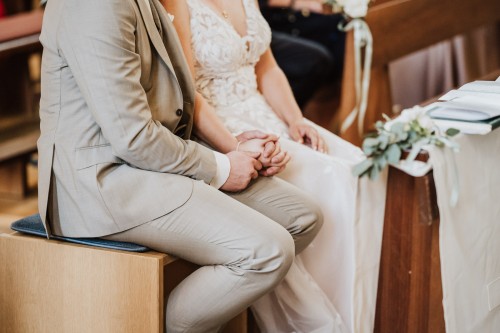 Eine Braut und Bräutigam halten Händchen.