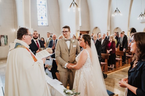 Ein Brautpaar steht mit allen Gästen in der Kirche.