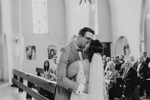 Ein Brautpaar küsst sich in einer Kirche.