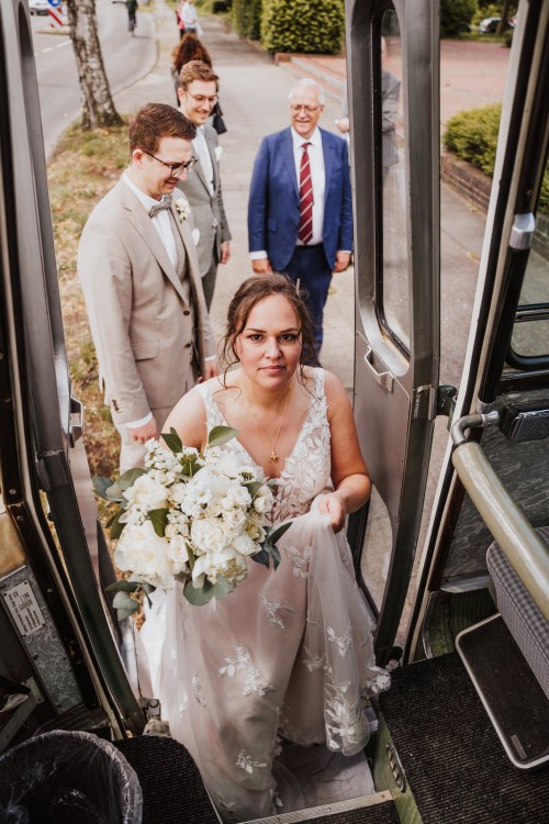 Eine Braut steigt in einen Bus.