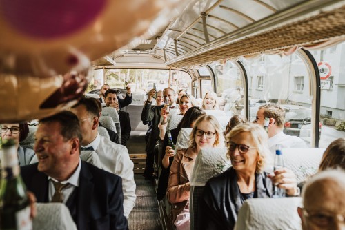 Hochzeitsgäste sitzen im Bus.