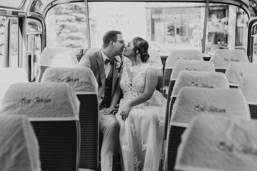 Ein Brautpaar sitzt im Bus und knutscht.