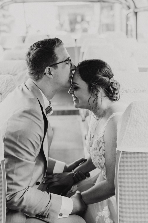 Ein Bräutigam gibt einer Braut einen Kuss auf die Stirn.