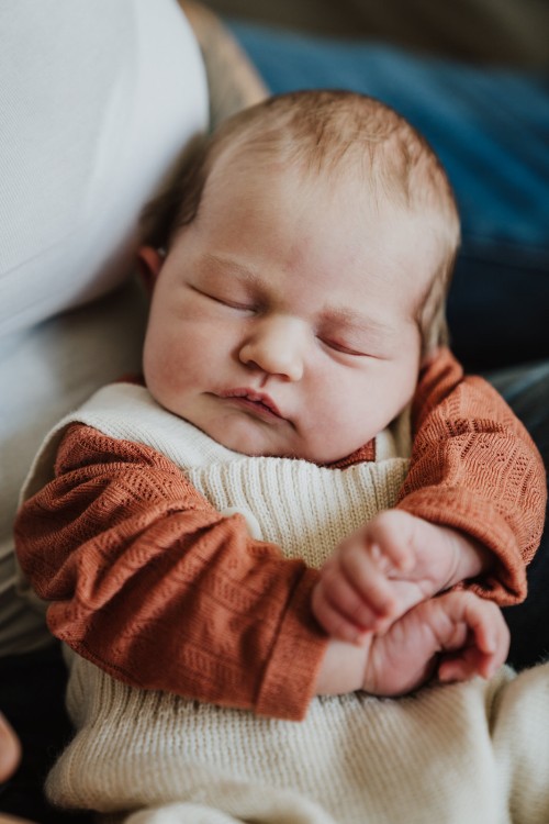 Schlafendes Baby bei der Mama auf ihren Schoß