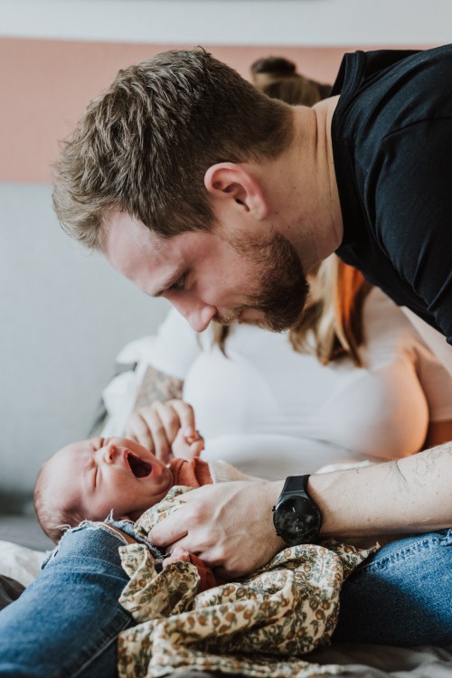 Das Baby gähnt während der Papa es genau beobachtet