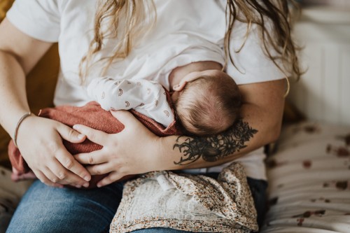 Eine Frau, die ein Baby im Arm hält.