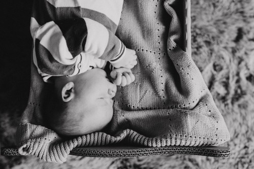 Ein schwarz-weißes Bild von einem Baby, das auf einer Decke liegt
