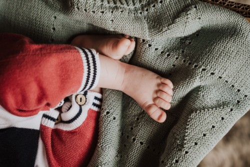 Babyfüße auf einer grüner Decke