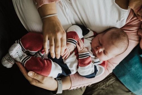 Ein neugeborenes Baby schläft in Mamas Armen