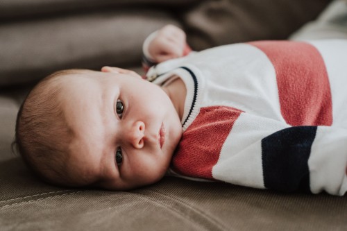 Ein kleines Baby liegt auf der Couch