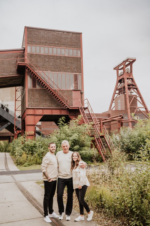 Zwei Männer und eine Frau posieren für ein Familienfoto auf der Zeche Zollverein.
