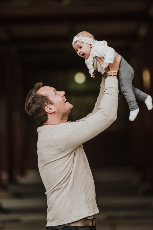 Ein Mann, der ein Baby hoch wirft.