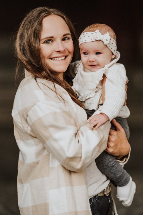 Eine Frau, die ein Baby im Arm hält.