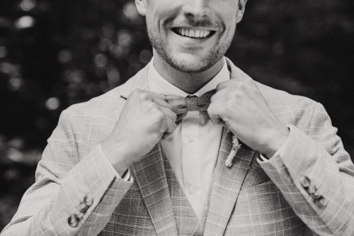 Ein Bräutigam richtet seine Fliege.