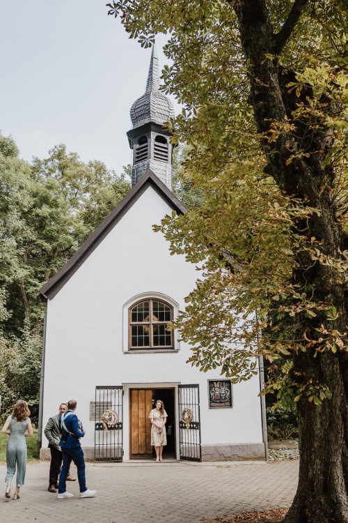 Eine kleine Kirche umgeben von Bäumen.
