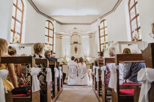 Ein Brautpaar sitzt in einer Kapelle.