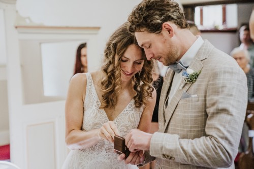 Ein Brautpaar holt aus einer Schatulle die Ringe heraus.