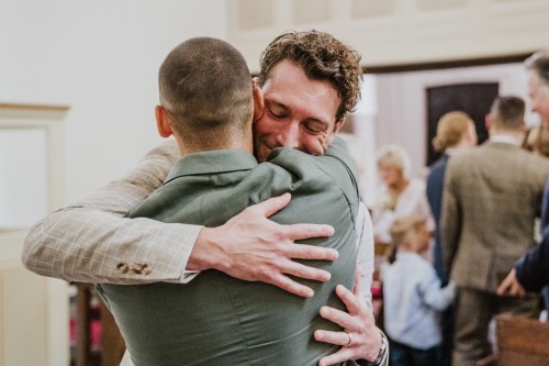 Ein Mann umarmt einen Bräutigam.