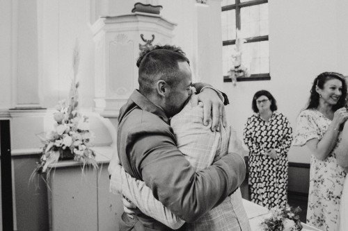 Ein Mann umarmt einen Bräutigam.