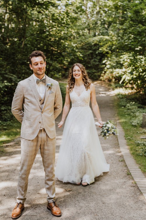 Eine Braut steht hinter dem Bräutigam.