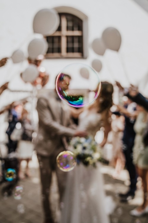 Seifenblasen und ein Brautpaar im Hintergrund.