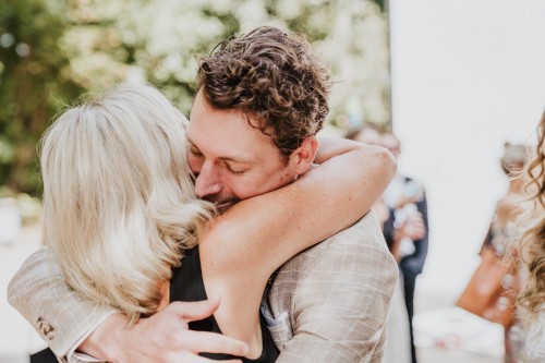 Eine Frau umarmt einen Bräutigam.