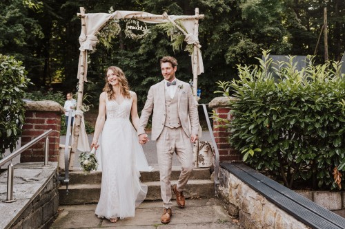 Eine Braut und ein Bräutigam gehen bei ihrer Hochzeit den Gang entlang.