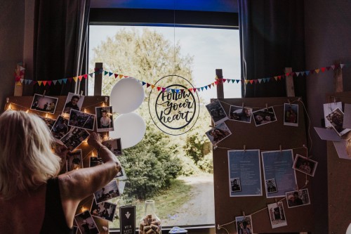 Eine Wand mit vielen Fotos und einem Schild.