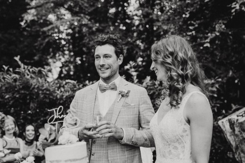 Ein Brautpaar steht vor einer Hochzeitstorte.