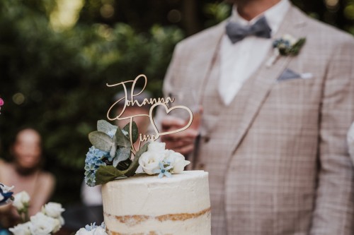 Eine Hochzeitstorte mit einem Schild.